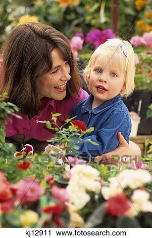 1990s SMILING MOTHER IN THE GARDEN WITH ARM AROUND BLOND DAUGHTER LOOKING AT CAMERA View Large Photo Image Stock Image - 1990s SMILING MOTHER IN THE GARDEN WITH ARM AROUND BLOND DAUGHTER LOOKING AT CAMERA. Fotosearch