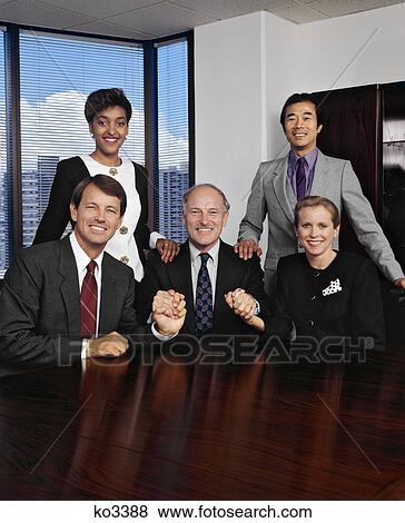 Stock Photo - 1990s WOMEN AND MEN IN BUSINESS MEETING IN CONFERENCE ROOM LOOKING AT CAMERA. Fotosearch