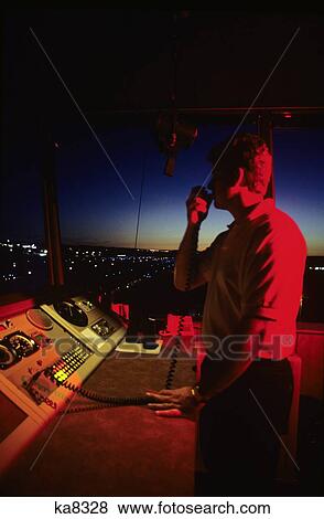 Stock Photo - Air Traffic Controller In Control Tower On Hand Held Radio. Fotosearch