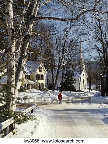 Stock Photograph - Anonymous Man Walking Down Icy Road Wearing Red Jacket And Hat In Grafton Vt Usa. Fotosearch