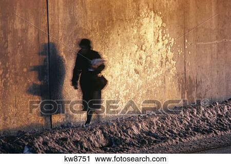 ANONYMOUS SILHOUETTED WOMAN WALKING ON SNOWY CITY STREET CASTING SHADOW ON WALL View Large Photo Image Stock Image - ANONYMOUS SILHOUETTED WOMAN WALKING ON SNOWY CITY STREET CASTING SHADOW ON WALL. Fotosearch
