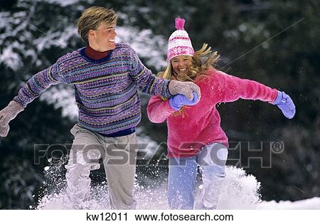 Stock Image - Couple Running In Snow Vail Colorado. Fotosearch