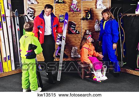 Stock Photography - Family In Ski Shop Dad Son Look Ay Ski Mom Daughter Trying On Boots. Fotosearch