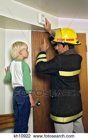 MAN FIREFIGHTER IN PROTECTIVE HELMET AND TURNOUT JACKET INSTRUCTING YOUNG BLOND BOY ABOUT HOME SMOKE DETECTOR FIRE ALARM View Large Photo Image Stock Image - MAN FIREFIGHTER IN PROTECTIVE HELMET AND TURNOUT JACKET INSTRUCTING YOUNG BLOND BOY ABOUT HOME SMOKE DETECTOR FIRE ALARM. Fotosearch