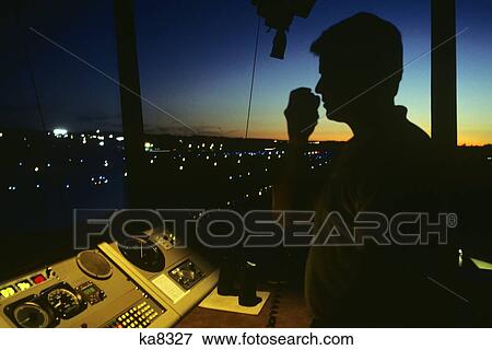 Silhouetted Air Traffic Controller In Control Tower On Hand Held Radio View Large Photo Image Stock Photo - Silhouetted Air Traffic Controller In Control Tower On Hand Held Radio. Fotosearch