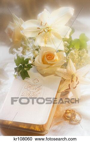 Stock Image - WEDDING STILL LIFE WITH BIBLE RINGS FLOWERS. Fotosearch