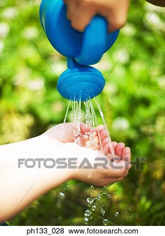 A child washing hands from a watering can View Large Photo Image Stock Photo - A child washing hands from a watering can. Fotosearch
