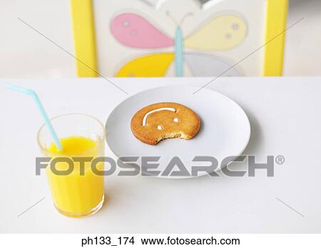 A glass of orange juice and a plate with a bitten cookie View Large Photo Image Picture - A glass of orange juice and a plate with a bitten cookie. Fotosearch