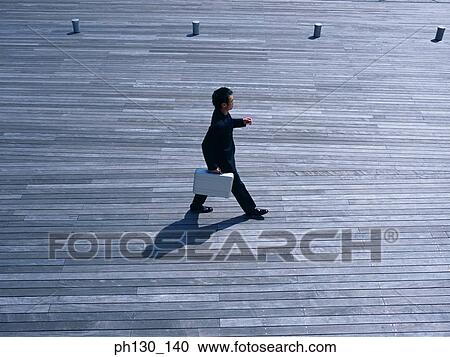 Aerial view of a man walking on a bridge View Large Photo Image Stock Image - Aerial view of a man walking on a bridge. Fotosearch