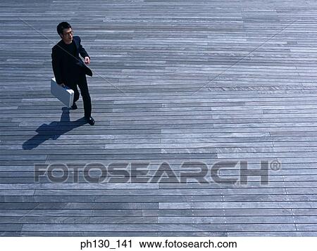 Aerial view of a man walking on a bridge View Large Photo Image Stock Image - Aerial view of a man walking on a bridge. Fotosearch