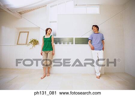 Stock Image - Asian couple standing in a room. Fotosearch