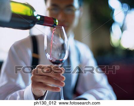 Stock Image - Asian Man accepting a glass of wine. Fotosearch