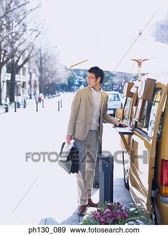 Stock Photo - Asian Man buying a snack from a vendor. Fotosearch
