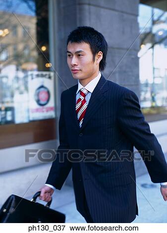 Stock Photo - Asian Man carrying a briefcase. Fotosearch