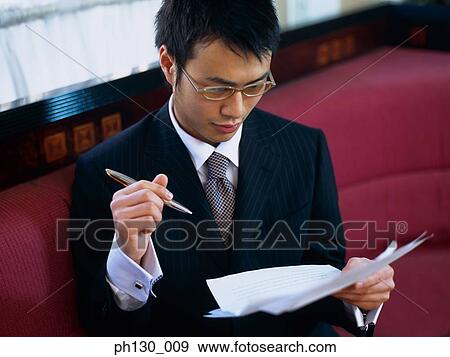 Asian Man checking documents View Large Photo Image Stock Photo - Asian Man checking documents. Fotosearch