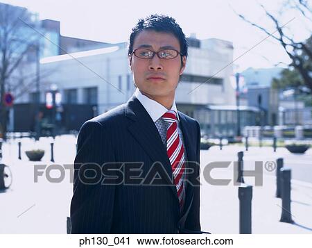 Stock Image - Asian Man crossing the street. Fotosearch