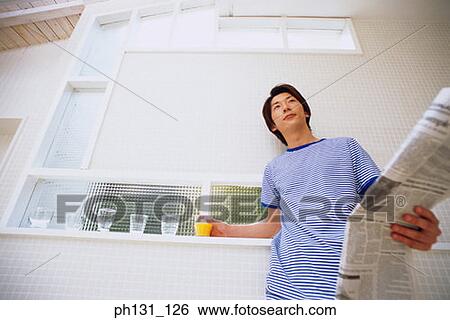 Stock Photograph - Asian man holding a newspaper. Fotosearch