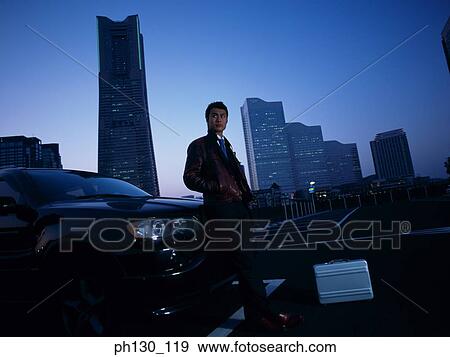 Asian Man leaning on a bonnet View Large Photo Image Stock Photo - Asian Man leaning on a bonnet. Fotosearch