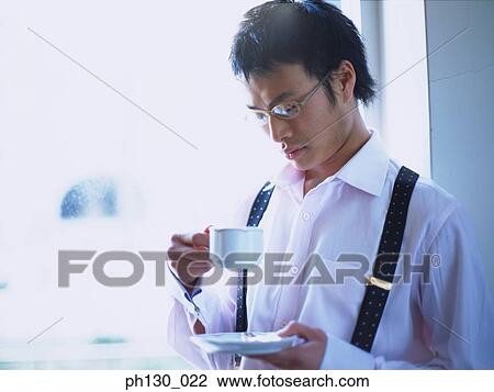 Asian Man looking into his cup of tea View Large Photo Image Stock Image - Asian Man looking into his cup of tea. Fotosearch