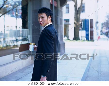 Picture - Asian Man looking over his shoulder. Fotosearch