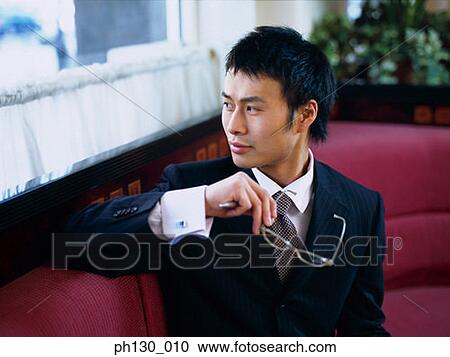 Stock Image - Asian Man looking over his shoulder. Fotosearch