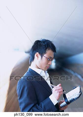 Asian Man making notes View Large Photo Image Stock Photo - Asian Man making notes. Fotosearch