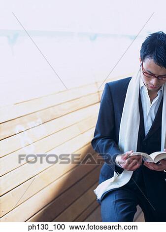 Asian Man reading on a bench View Large Photo Image Stock Image - Asian Man reading on a bench. Fotosearch