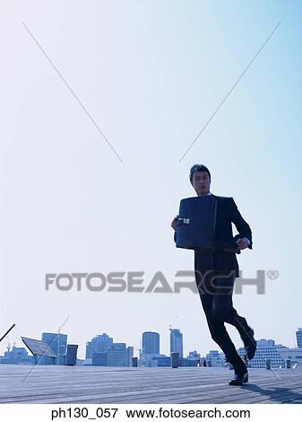 Stock Photo - Asian Man running on a walkway. Fotosearch