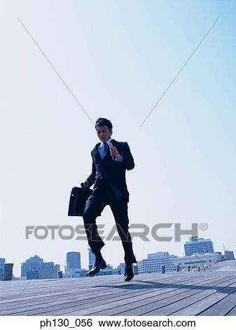 Asian Man running on a walkway View Large Photo Image Stock Photograph - Asian Man running on a walkway. Fotosearch