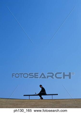 Stock Photography - Asian Man sitting and working on his laptop. Fotosearch