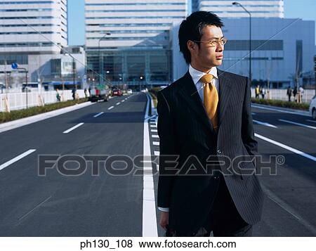 Asian Man standing in the middle of the street View Large Photo Image Stock Photo - Asian Man standing in the middle of the street. Fotosearch