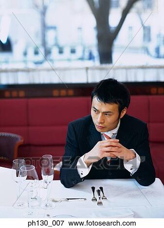 Asian Man waiting in a restaurant View Large Photo Image Stock Photo - Asian Man waiting in a restaurant. Fotosearch