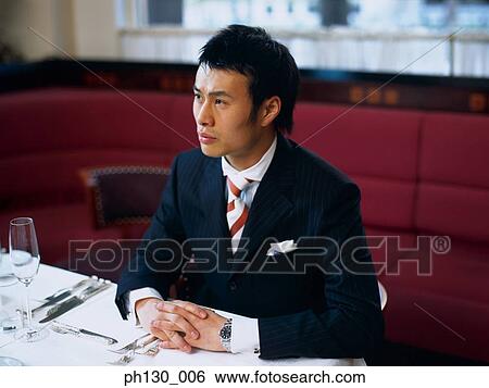 Asian Man waiting in a restaurant View Large Photo Image Stock Photograph - Asian Man waiting in a restaurant. Fotosearch