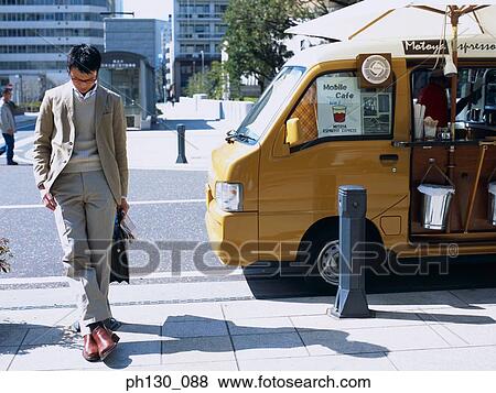 Stock Photo - Asian Man waiting on a sidewalk. Fotosearch