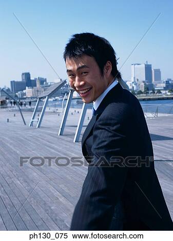 Asian Man walking on a bridge View Large Photo Image Stock Photography - Asian Man walking on a bridge. Fotosearch