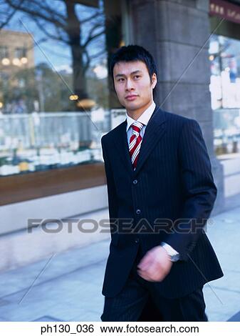 Asian Man walking on the sidewalk View Large Photo Image Stock Photograph - Asian Man walking on the sidewalk. Fotosearch