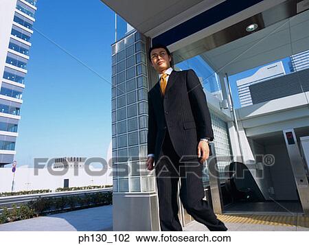 Asian Man walking out of an office View Large Photo Image Stock Image - Asian Man walking out of an office. Fotosearch