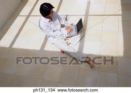 Picture - Asian man working on a laptop. Fotosearch