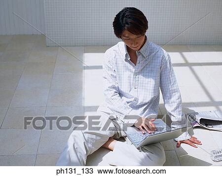 Asian man working on a laptop View Large Photo Image Stock Image - Asian man working on a laptop. Fotosearch