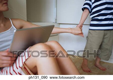 Stock Image - Asian mother and son holding hands. Fotosearch