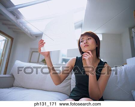 Asian woman reading a document View Large Photo Image Stock Image - Asian woman reading a document. Fotosearch