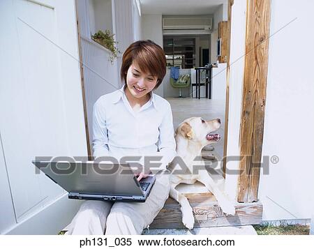Stock Photography - Asian Woman sitting with her dog. Fotosearch