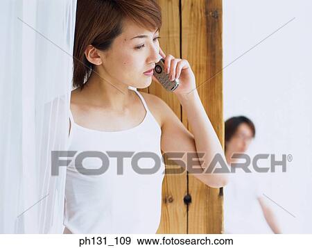 Stock Photo - Asian woman talking on the cell phone. Fotosearch