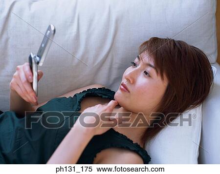 Asian woman using a cell phone View Large Photo Image Stock Photography - Asian woman using a cell phone. Fotosearch