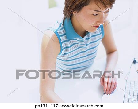 Asian woman working on a desk View Large Photo Image Stock Photo - Asian woman working on a desk. Fotosearch
