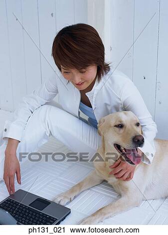 Stock Image - Asian Woman working on a laptop. Fotosearch