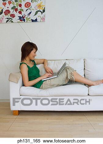 Asian Woman working on a laptop View Large Photo Image Stock Photography - Asian Woman working on a laptop. Fotosearch