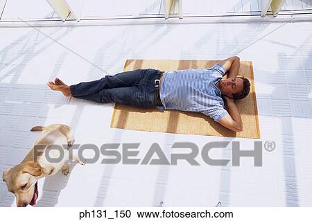 Stock Image - Caucasian man asleep on the floor. Fotosearch