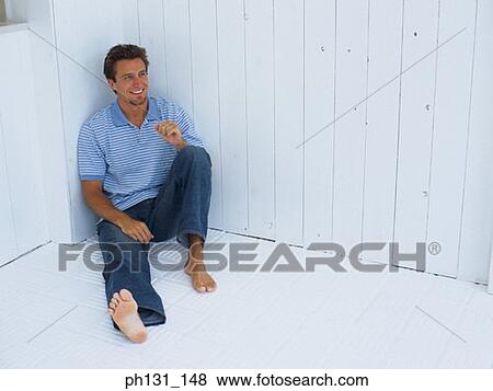 Caucasian man sitting on the floor View Large Photo Image Stock Photo - Caucasian man sitting on the floor. Fotosearch