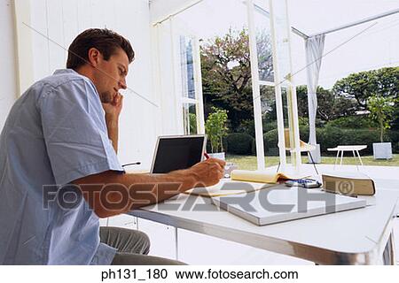 Caucasian man working on a desk View Large Photo Image Stock Image - Caucasian man working on a desk. Fotosearch